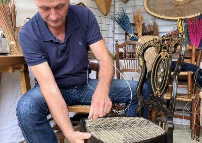 Photo de Didier Marchand aux journées du patrimoine à Luçon 21-22 septembre 2024 en cours de réalisation d'un cannage traditionnel.